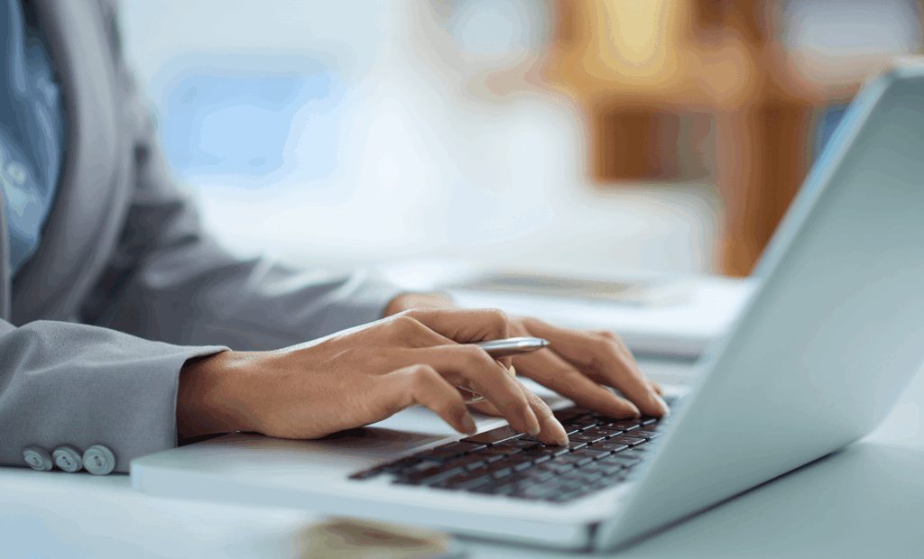Diversidade. Uma mão feminina e branca mexendo em um notebook. 