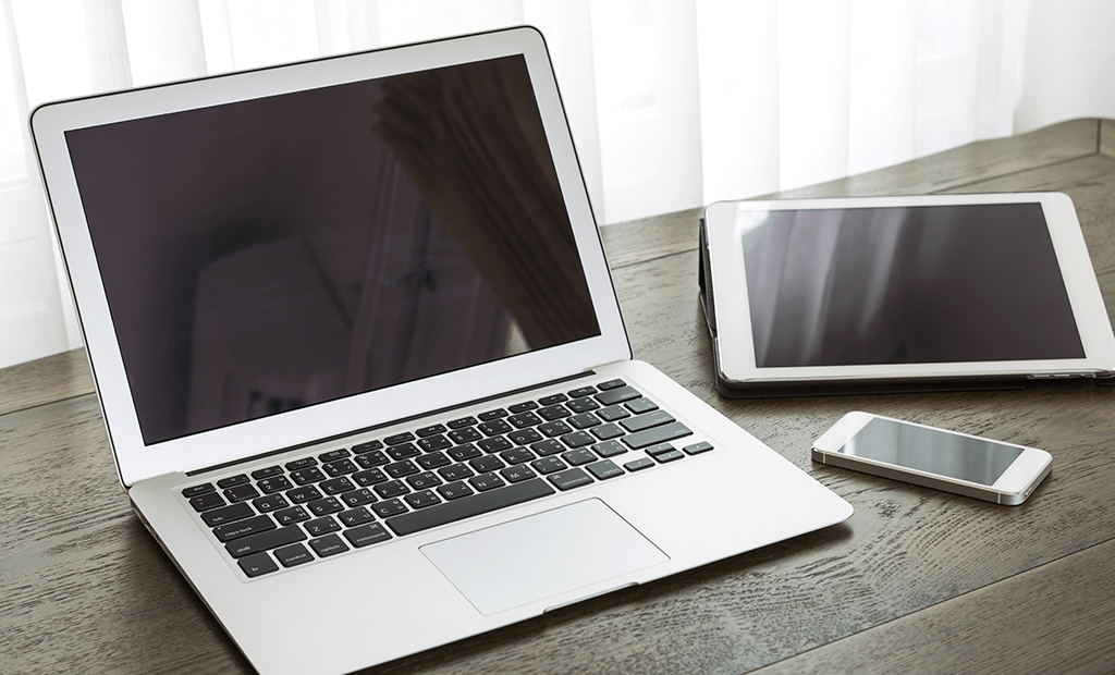 Representatividade. Imagem de um computado, um notebook e um celular em cima de uma mesa. 