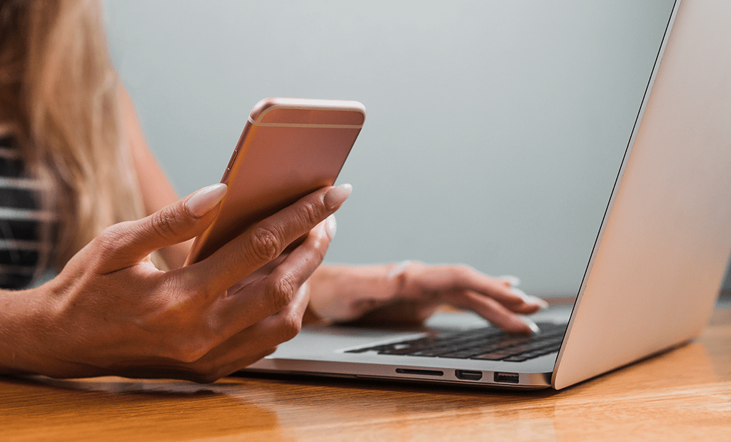 Representatividade. Imagem de uma mão feminina mexendo em um notebook e na outra mão mexendo no celular. 